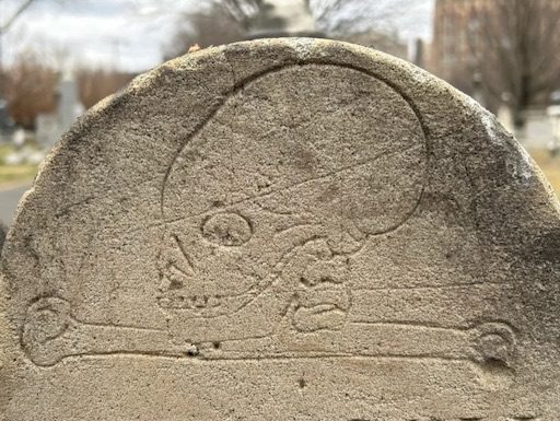 Close-up of the Pascoe children's gravestone in the Presbyterian Cemetery, featuring a hand-carved skull and crossbones symbolizing mortality—photo by D. Heiby.