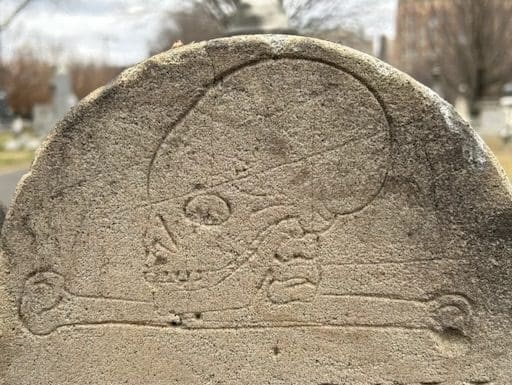 Close-up of the Pascoe children's gravestone in the Presbyterian Cemetery, featuring a hand-carved skull and crossbones symbolizing mortality—photo by D. Heiby.