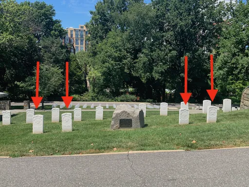 Granite boulder memorial with bronze plaque honoring four civilian Quartermaster employees killed in the Black Diamond disaster, located in Alexandria National Cemetery.