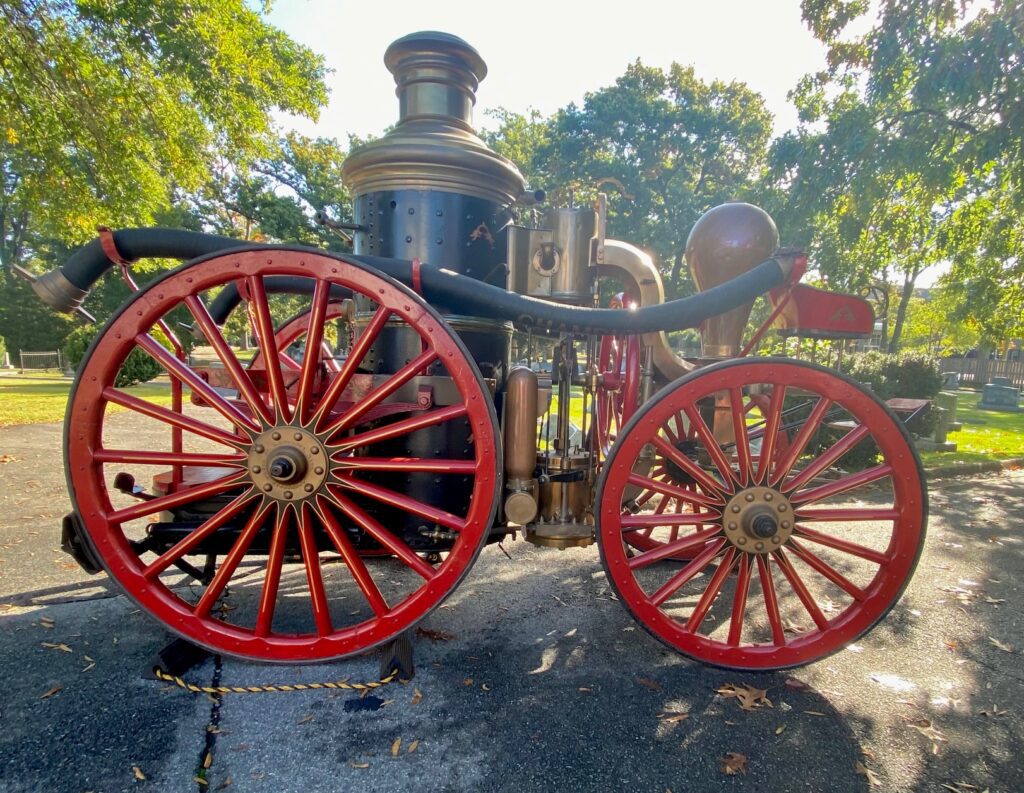 Historic horse-drawn steam fire engine with large wheels and mounted boiler, one of the first steam-powered firefighting engines used in Alexandria. Preserved by the city. Image courtesy of historian Catherine Weinraub.