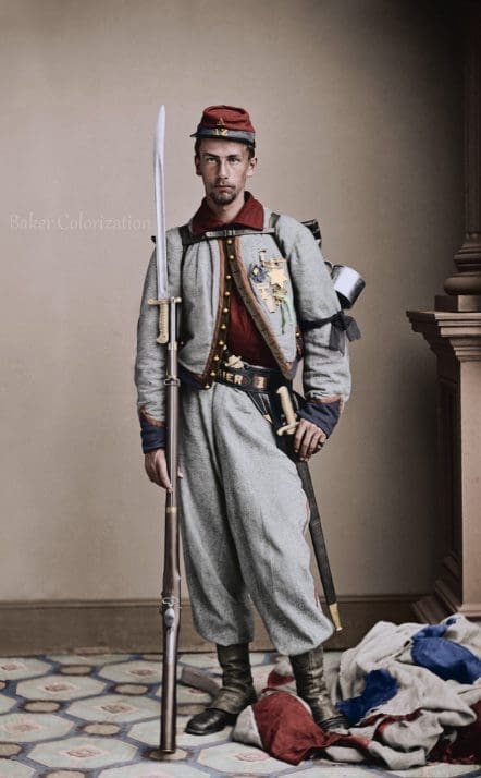 Civil War-era portrait of a soldier from the 11th New York Volunteer Infantry (Fire Zouaves), wearing a colorful Zouave uniform with a blue jacket and red trousers.