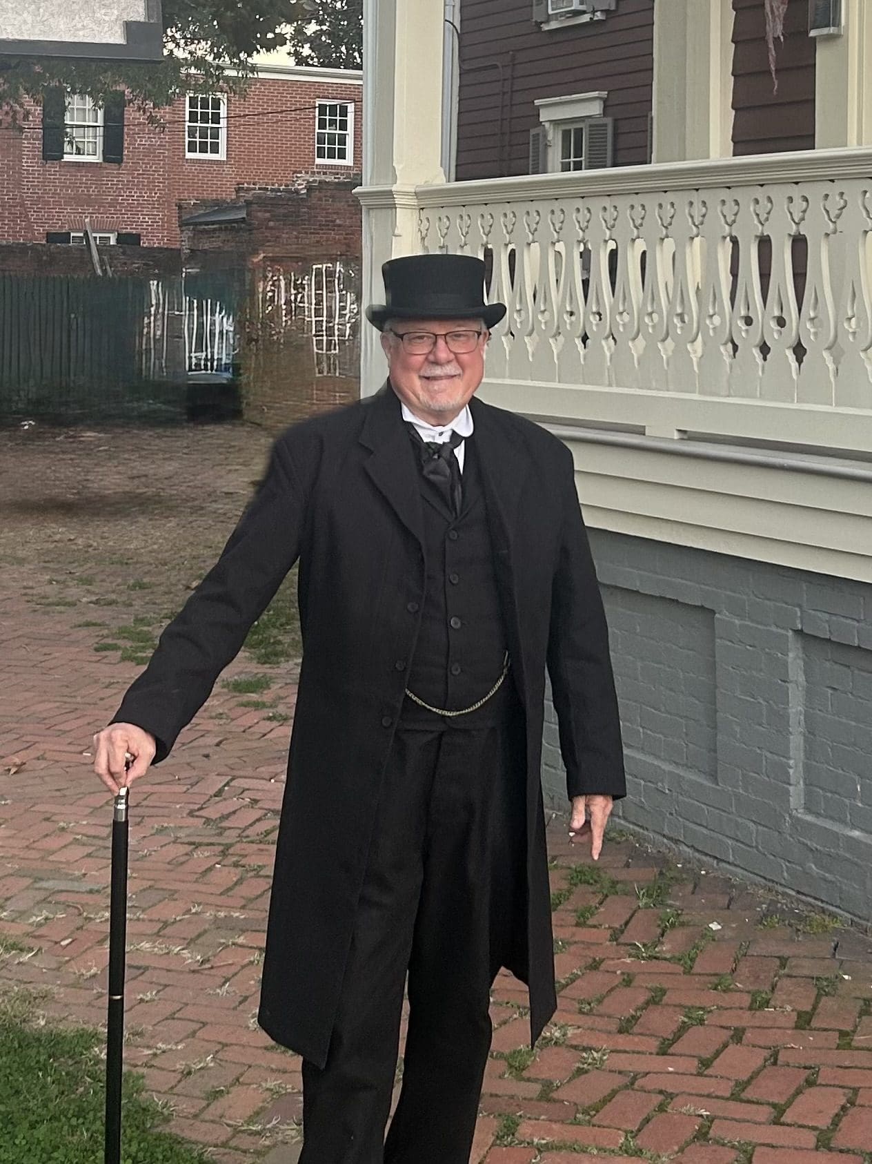 Public historian David Heiby portraying Mayor E. E. Downham outside the Lee-Fendall House Museum in Alexandria, Virginia, dressed in 19th-century formal attire with top hat and walking cane.