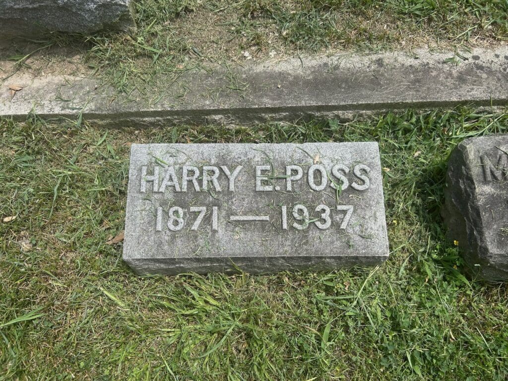 Gravestone reading Harry E. Poss, 1871–1937, lying in grass in the Presbyterian Cemetery, Alexandria, Virginia. 